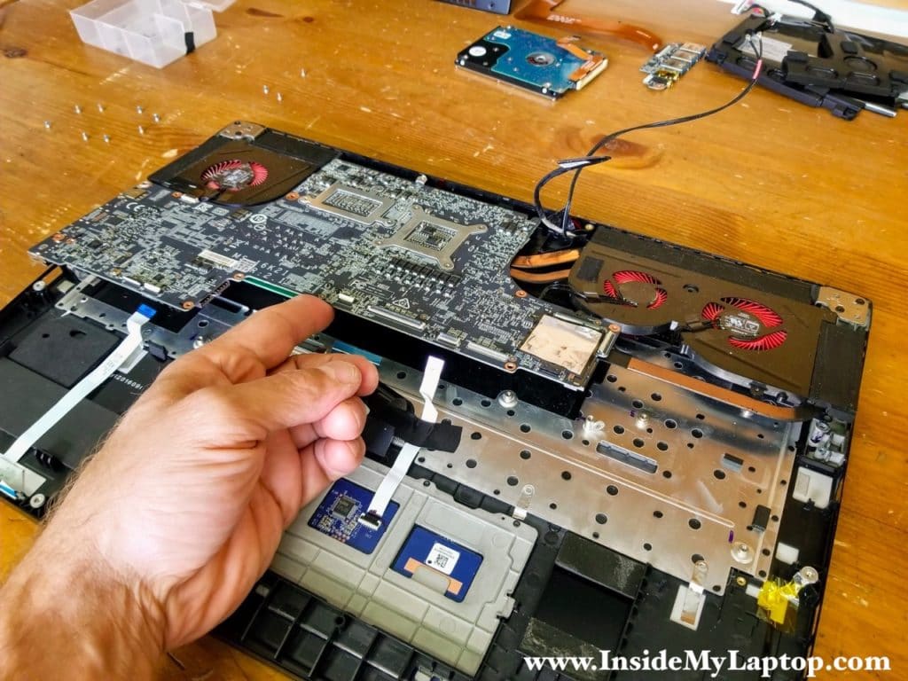 Start separating the motherboard from the top case.