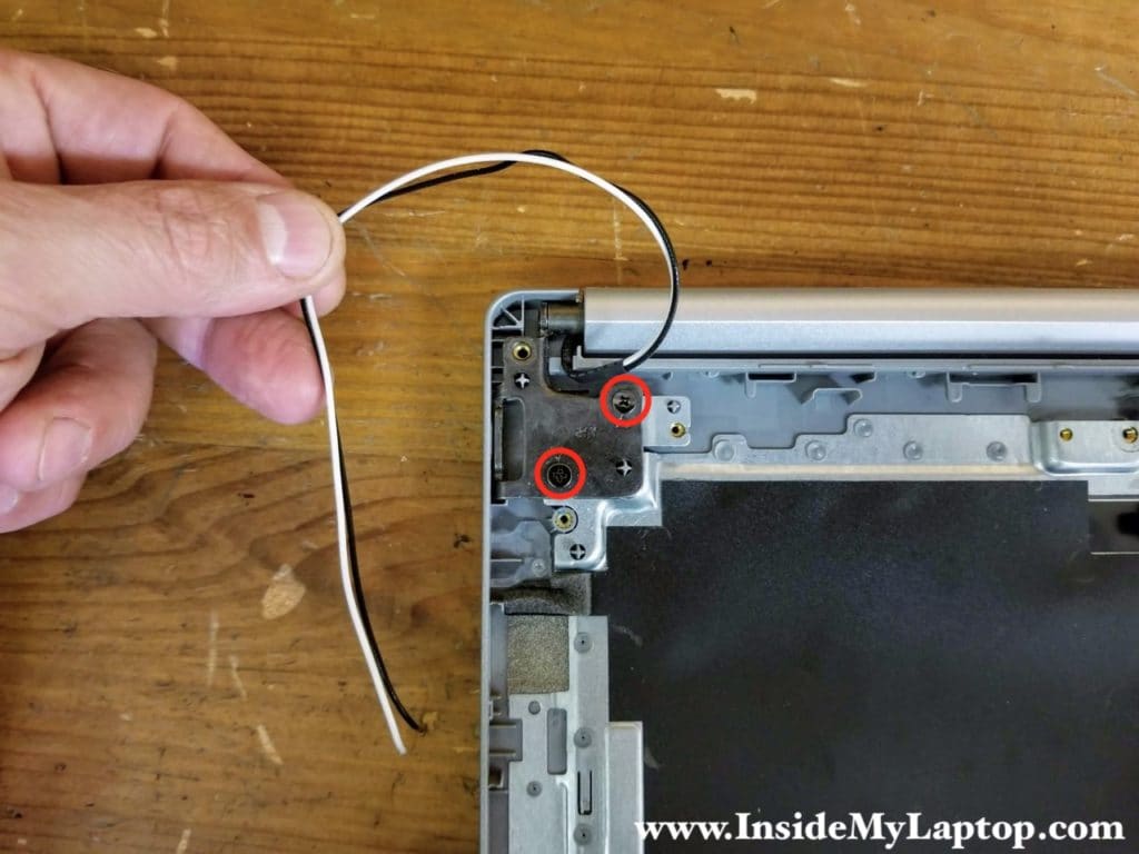 Remove two screws from the right display hinge. Un-route the wireless antenna cables from the guided path on the top case.