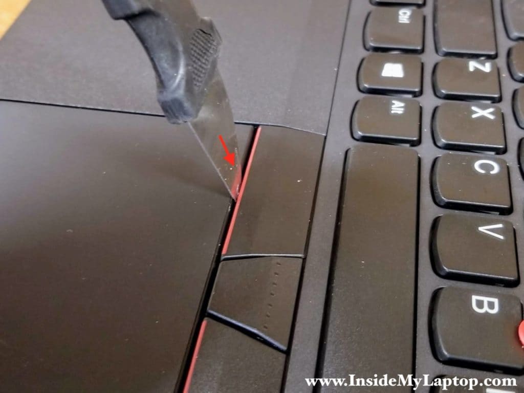 Insert a thin case opener tool under the left trackpad button.