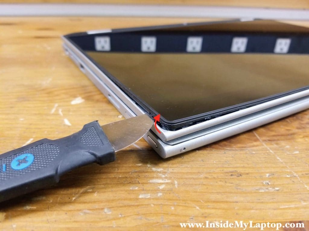 Start separating the touchscreen assembly from the display back cover using a thin case opener tool.