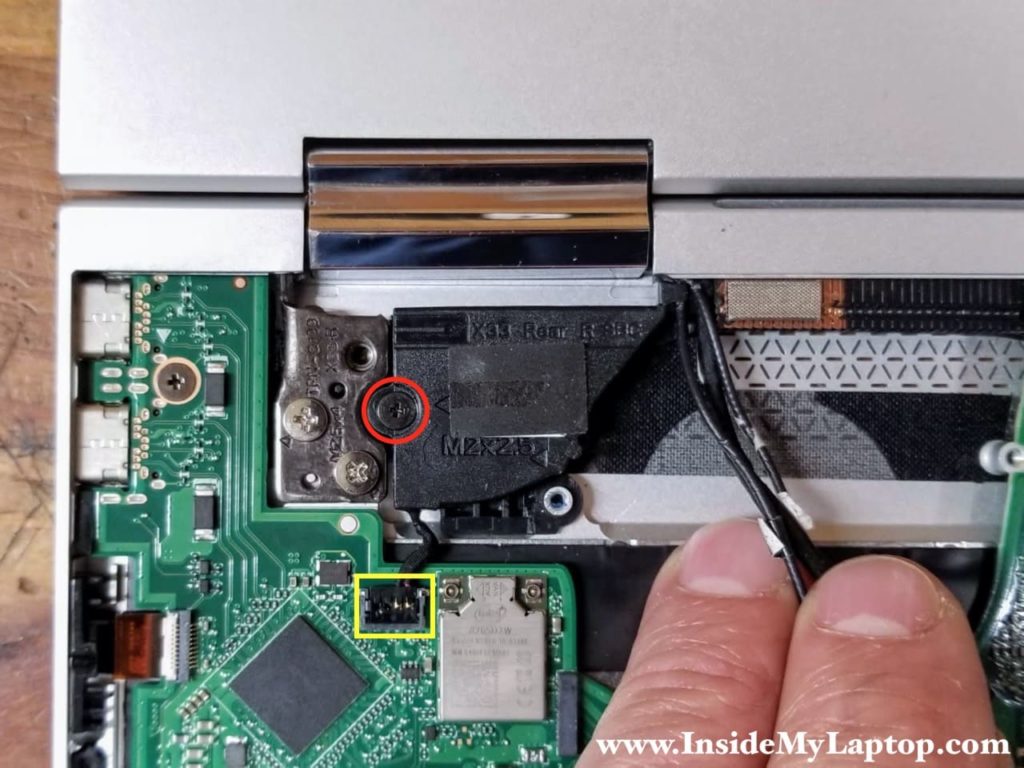 Remove one screw from the rear right speaker and disconnect the cable.